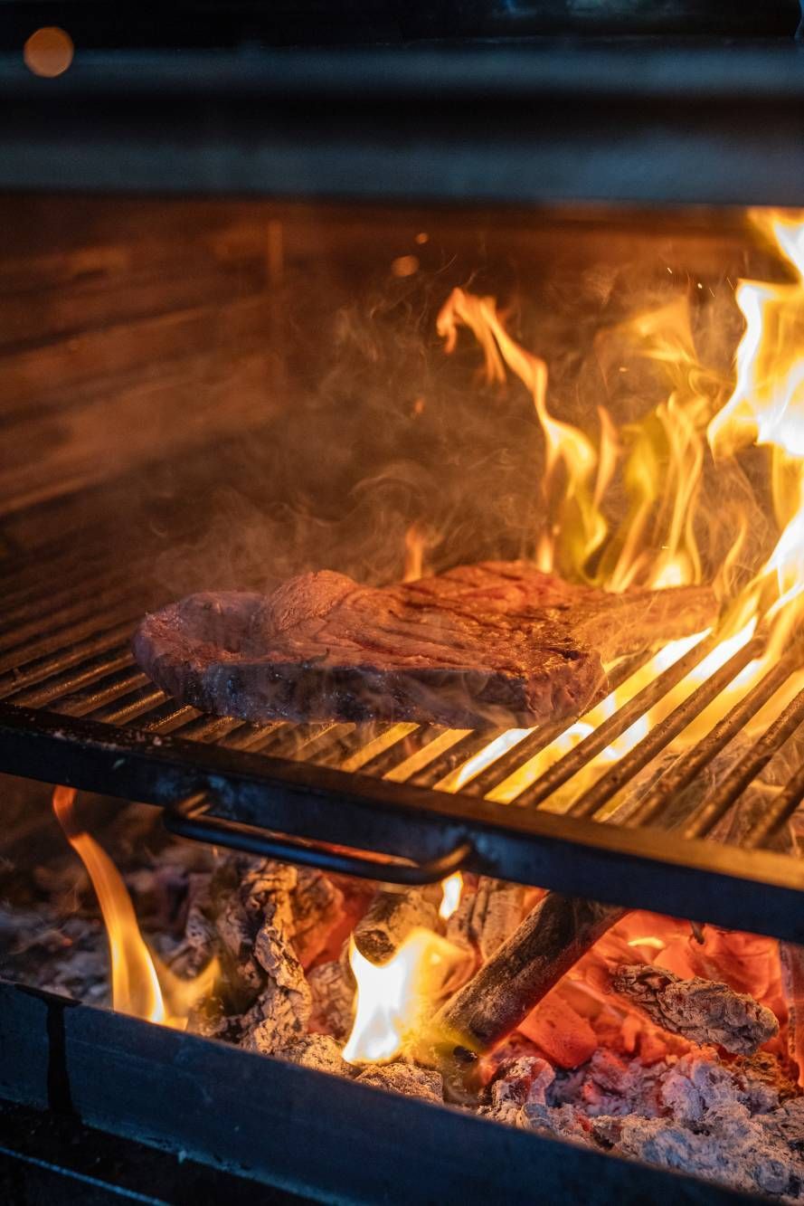 Un filete se cocina en una parrilla sobre el fuego.