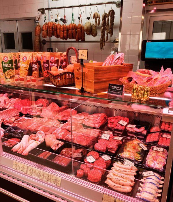 Una vitrina de carnicero llena de carne y embutidos.