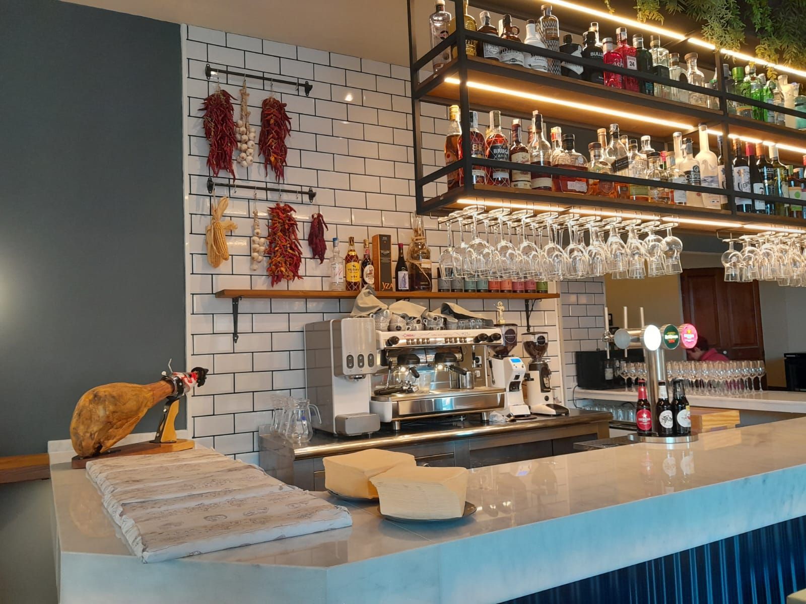 Un bar con muchas botellas y vasos encima.