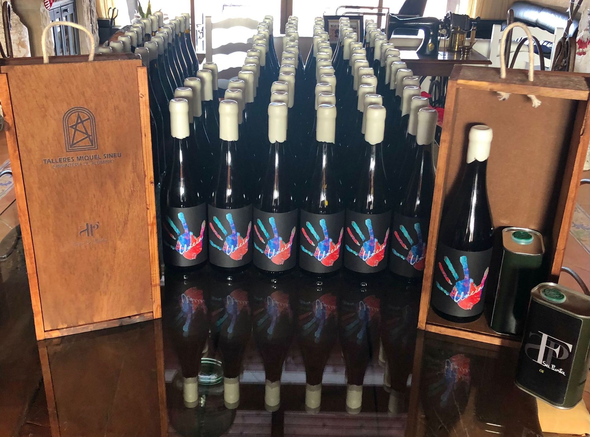 Muchas botellas de vino están alineadas sobre una mesa.