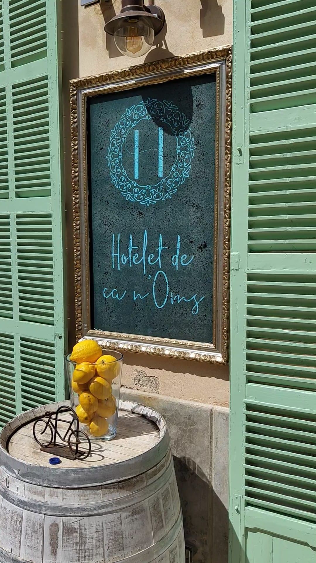 Un cartel en una pared al lado de un barril con limones.