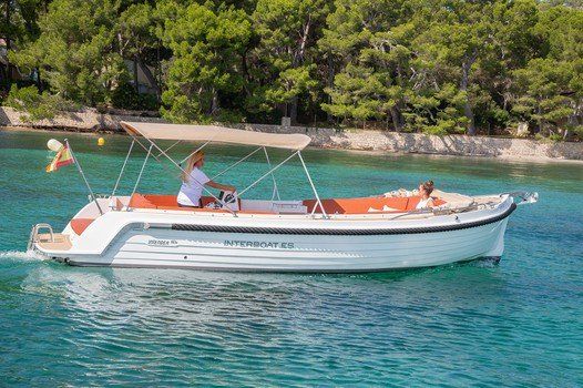 Un barco blanco con un dosel flota sobre un cuerpo de agua.