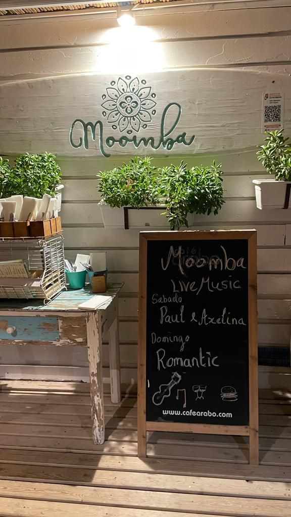 Una pizarra está colocada sobre una mesa de madera frente a una pared de madera.