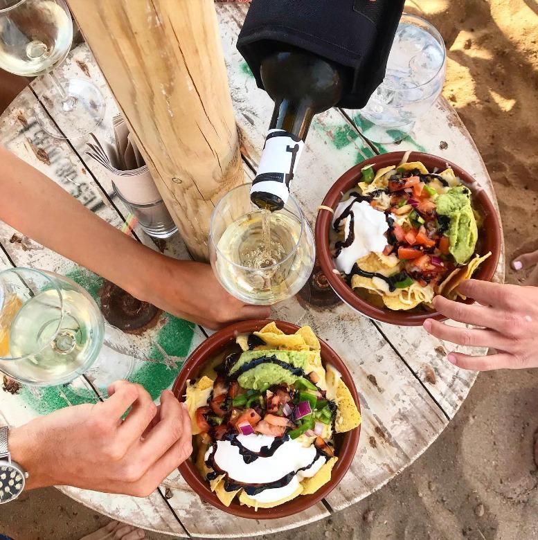 Se vierte una botella de vino en un recipiente con comida.