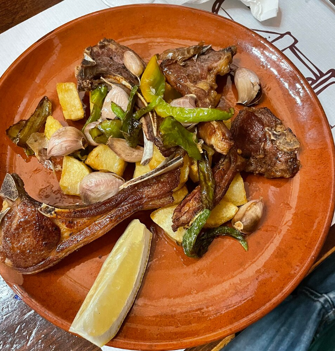 Un plato de comida con una rodaja de limĂłn encima.