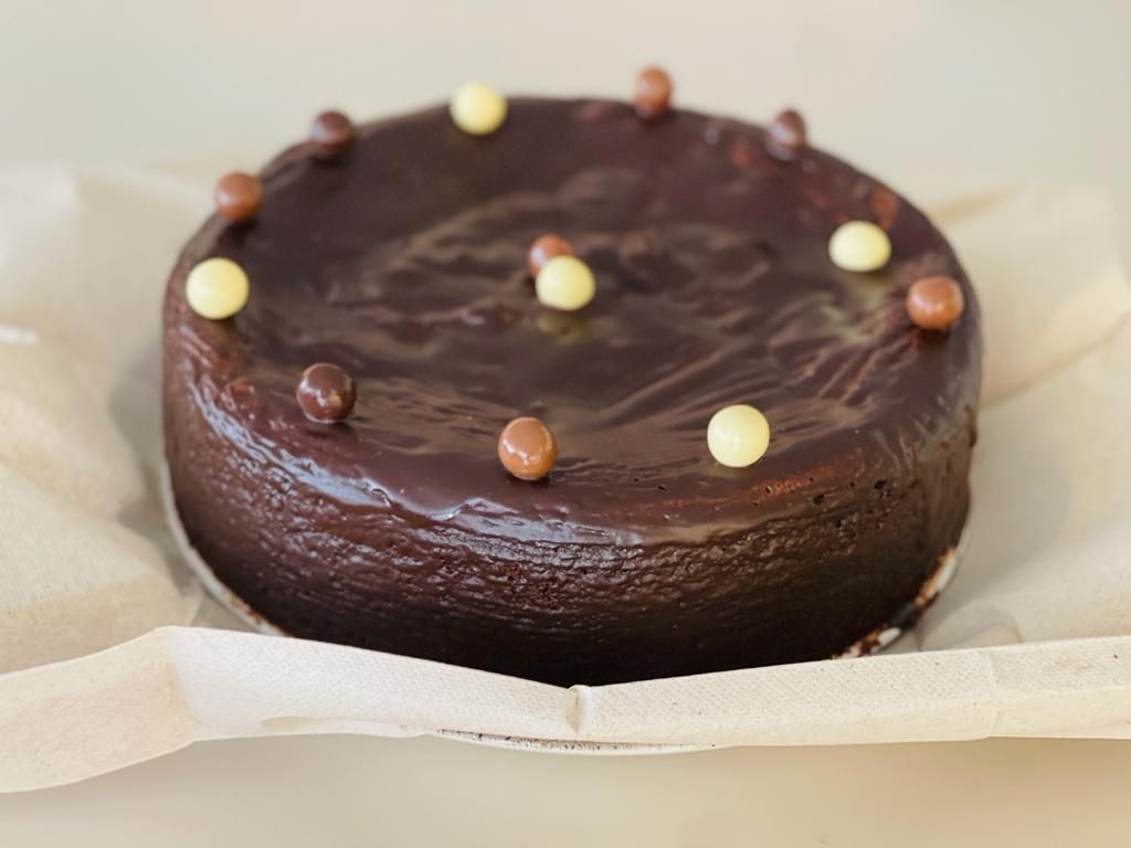 Un pastel de chocolate con bolas de chocolate encima.