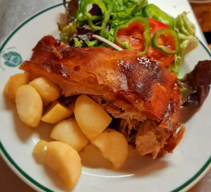 Un plato de comida con patatas y verduras encima.