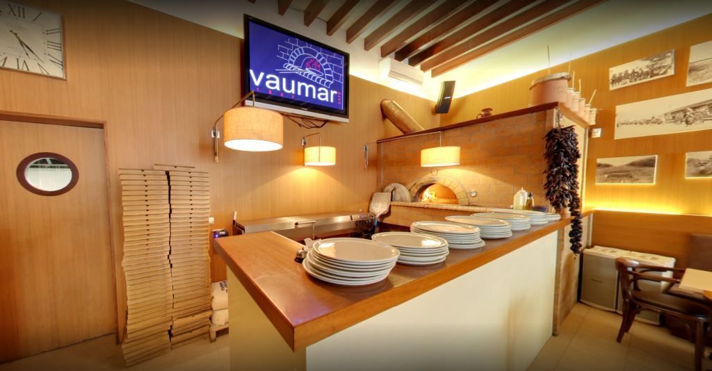 Un restaurante con platos en el mostrador y un televisor en la pared.