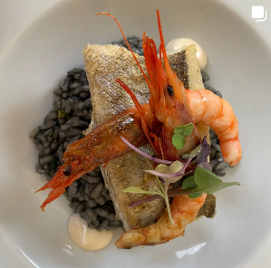 Un plato de comida con camarones y arroz encima.
