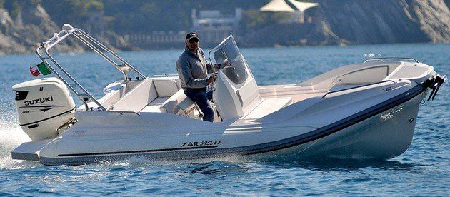 Un hombre conduce un barco blanco en el océano.
