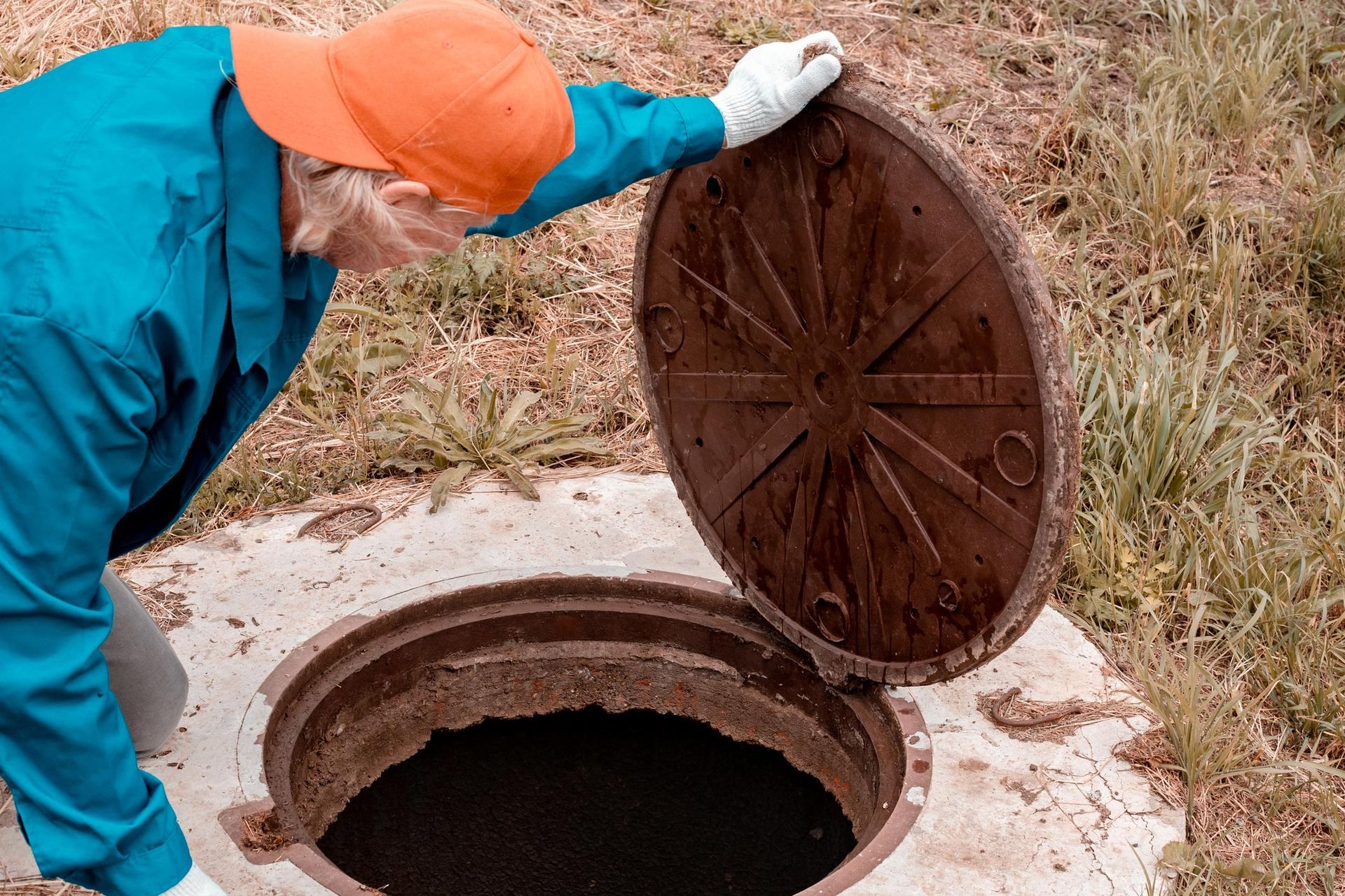 A worker opened the well hatch and looked inside. A worker opened the well hatch and looked inside.