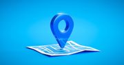 Blue map pin marker on a folded map against a bright blue background.
