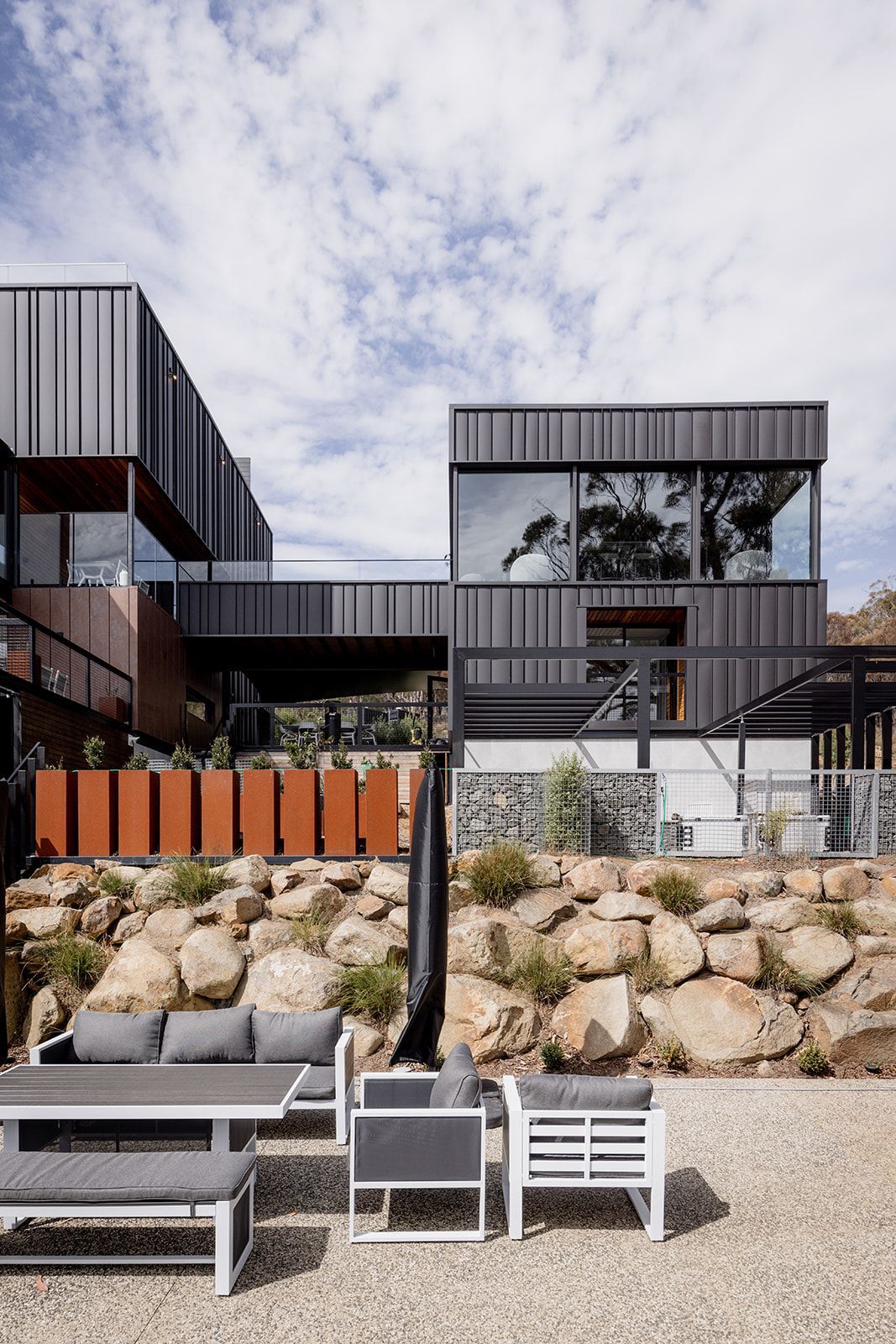 A large house with a lot of windows and a lot of furniture in front of it.