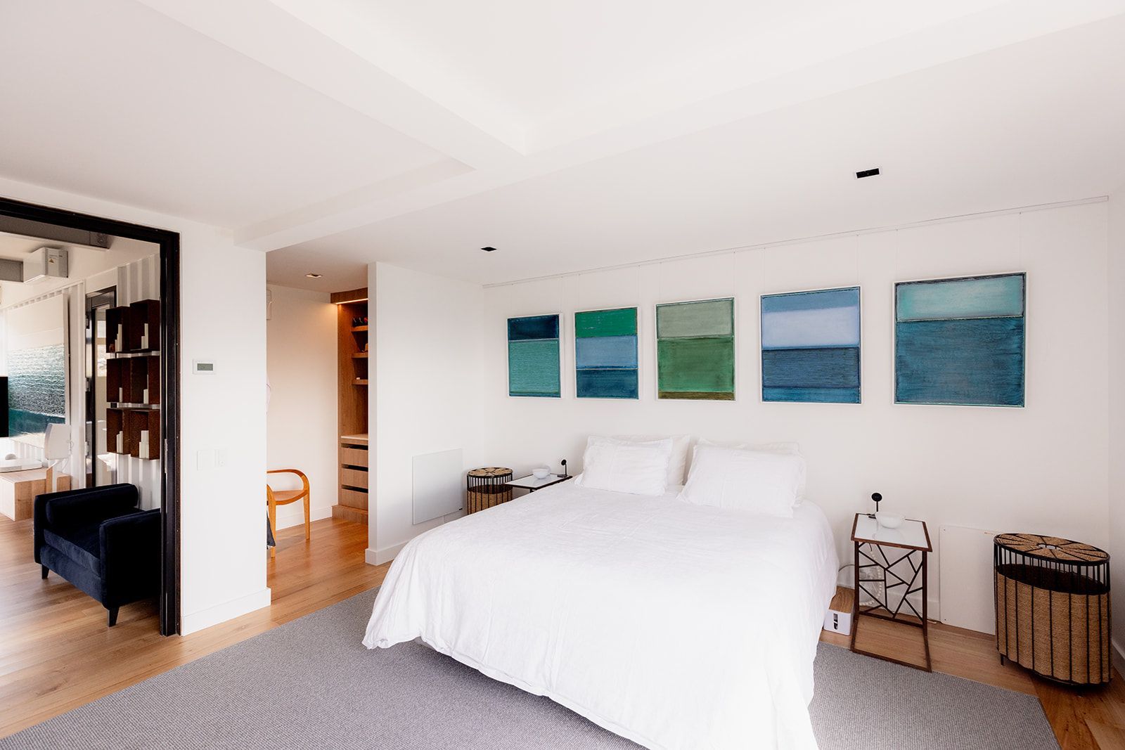 A bedroom with a large bed and paintings on the wall