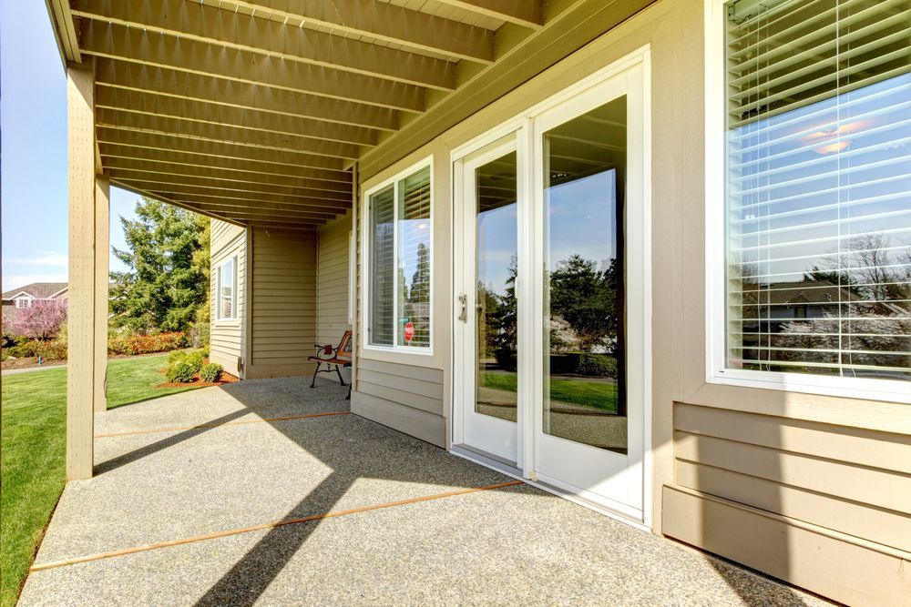 There is a Patio With Sliding Glass Doors and a Pergola — Glen Lamberts Wall Cladding & Home Improvements in Wauchope, NSW