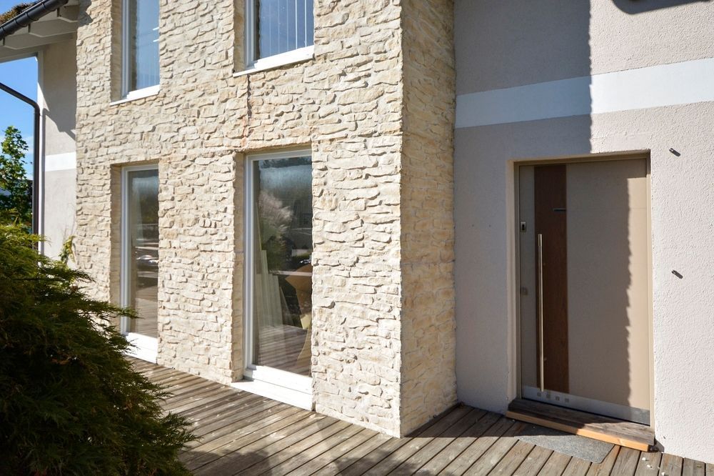 A House With a Stone Facade and a Wooden Deck — Glen Lamberts Wall Cladding & Home Improvements in Laurieton, NSW