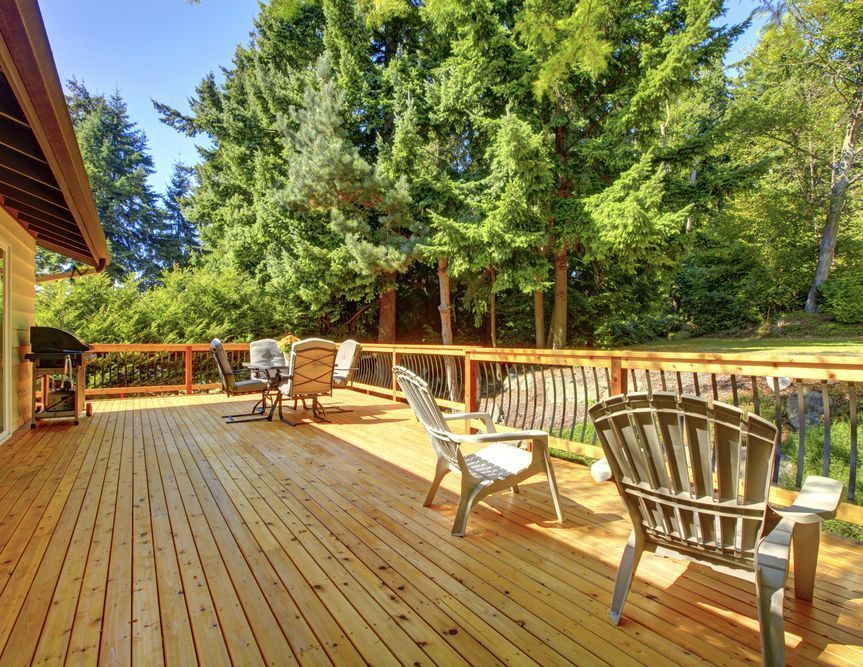 A Large Wooden Deck With Chairs, a Table and a Grill — Glen Lamberts Wall Cladding & Home Improvements in Tuncurry, NSW