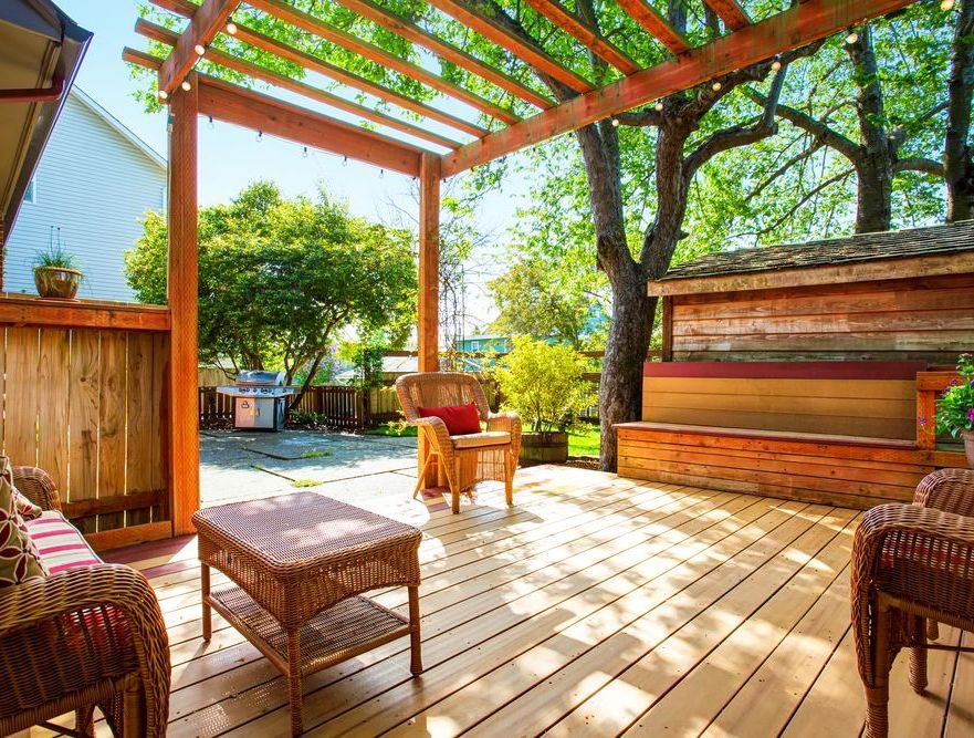A Wooden Deck With Wicker Furniture and a Pergola — Glen Lamberts Wall Cladding & Home Improvements in Tuncurry, NSW