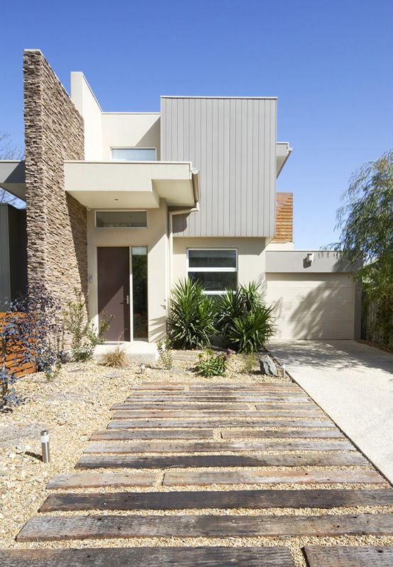 A Modern House With a Wooden Driveway Leading to It — Glen Lamberts Wall Cladding & Home Improvements in Wingham, NSW