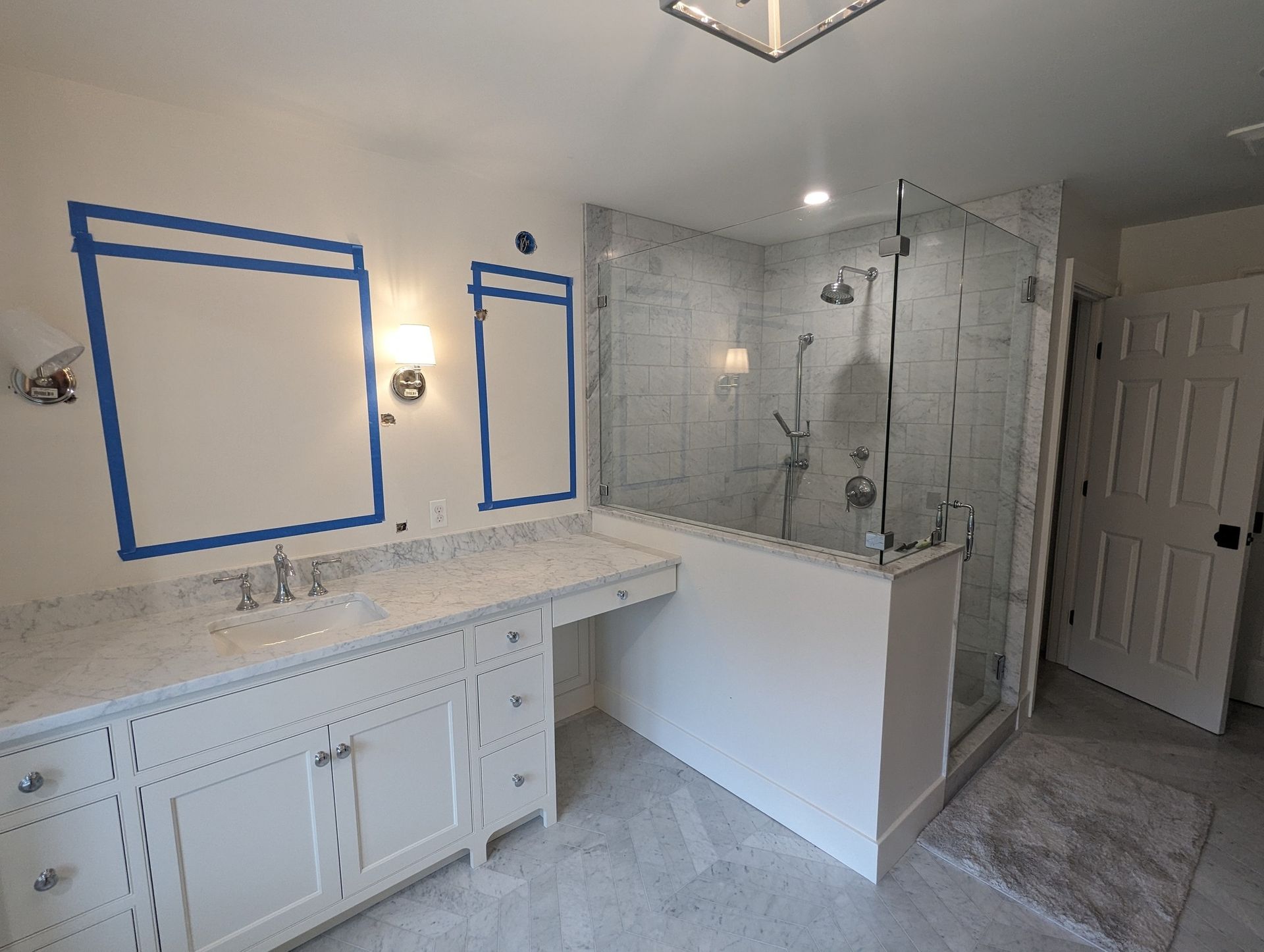 Modern bathroom with double vanity, large mirror, glass shower, and tub in white tile.