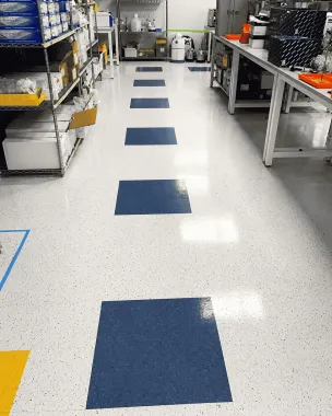 Warehouse aisle with blue floor markers and metal shelves on both sides