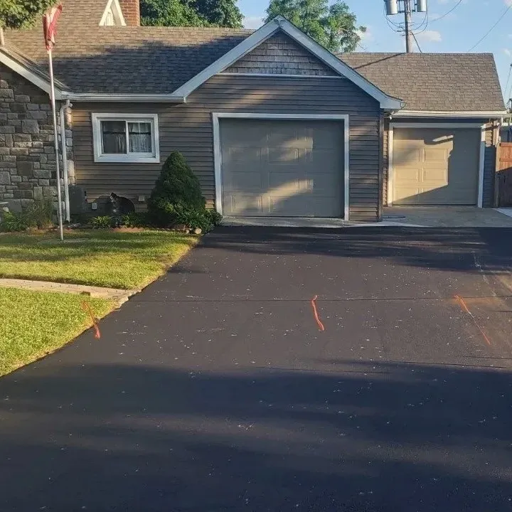 A driveway leading to a house, asphalt paving company, DJs Paving.