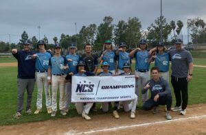 Baseball team posing on field with WCS Championships banner and trophy, smiling after a win