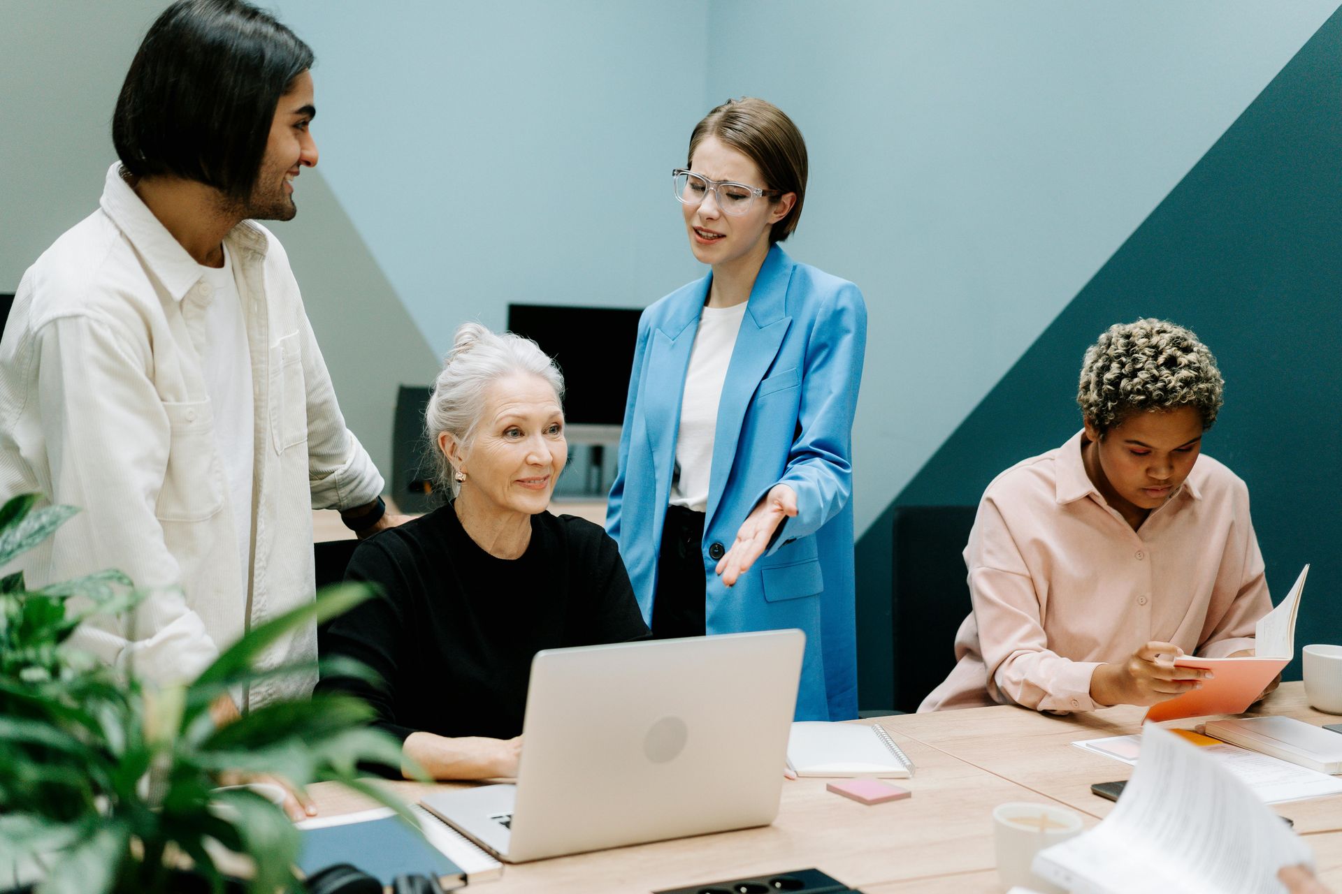 Business team meeting with senior woman and laptop