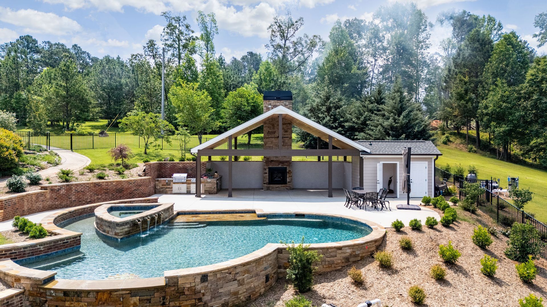 Gunite pool with pavilion, stone fireplace, outdoor kitchen, bathroom and storage overlooking Lake Keowee