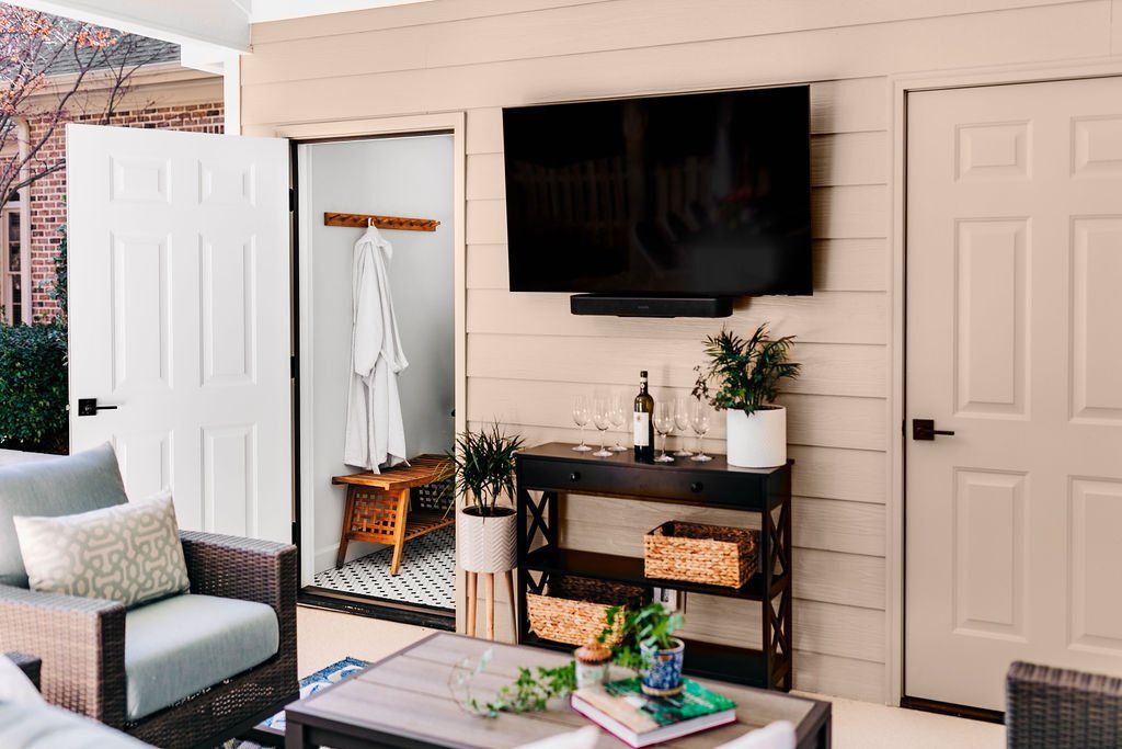 Outdoor patio with wall-mounted TV, open closet nook, and seating area with coffee table