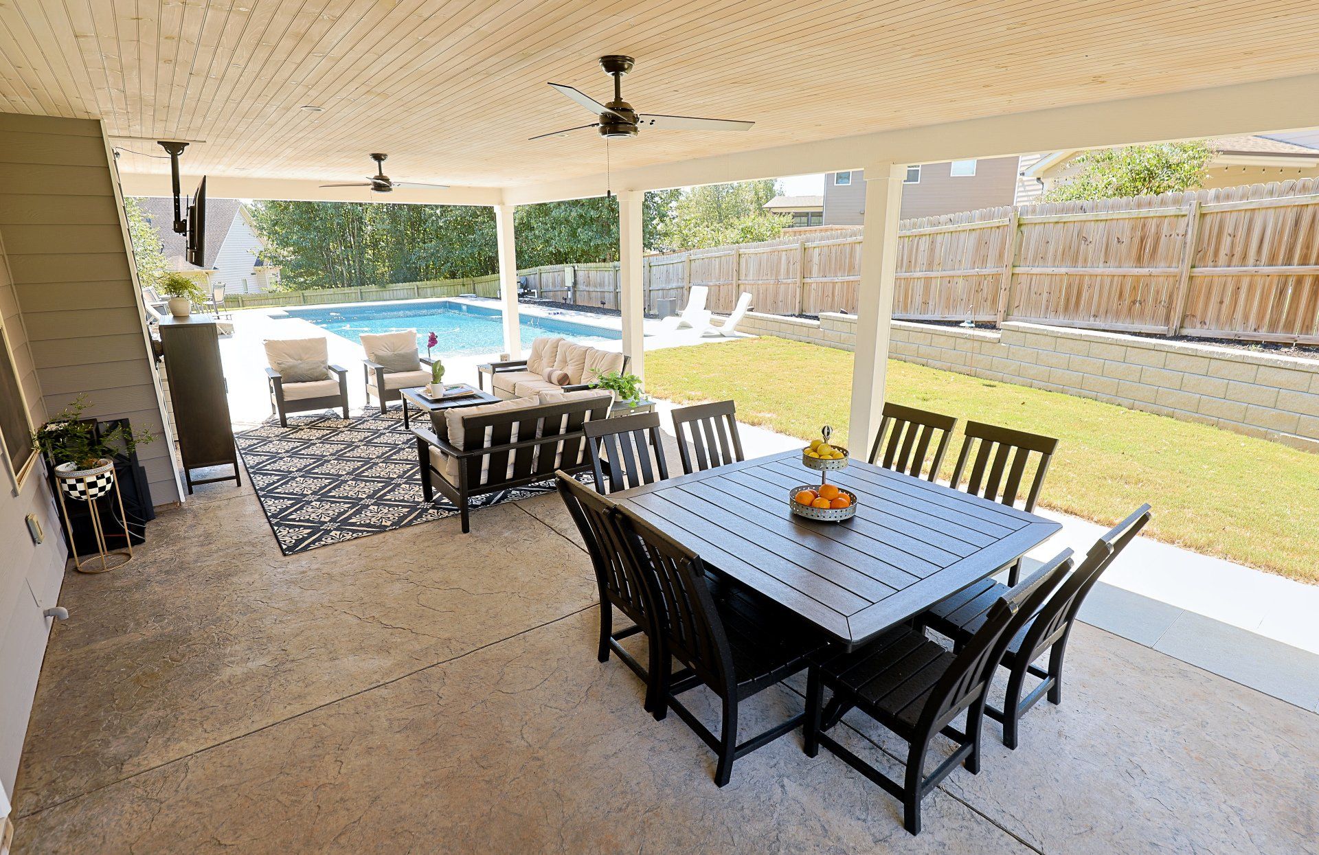 Covered patio with dining table, chairs, lounge seating, and a backyard view