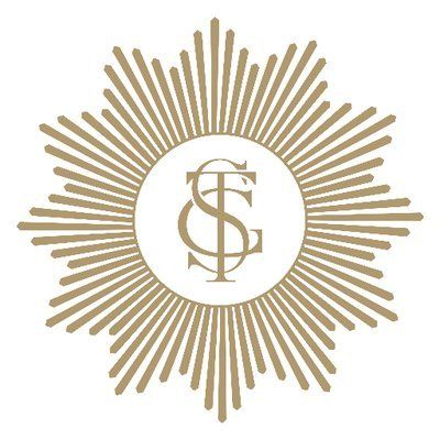 Gold sunburst monogram logo with intertwined letters inside a circle