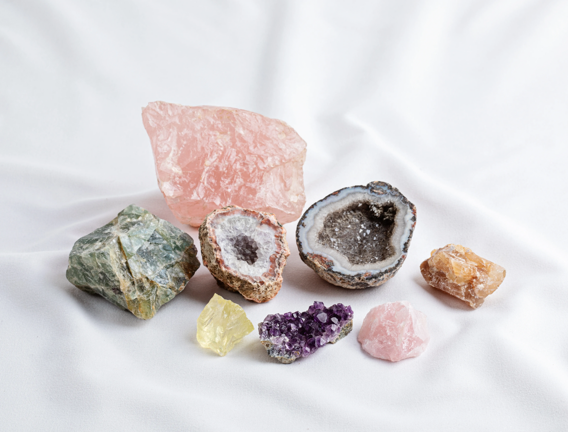 Various colorful crystals and gemstones on a beige cloth.