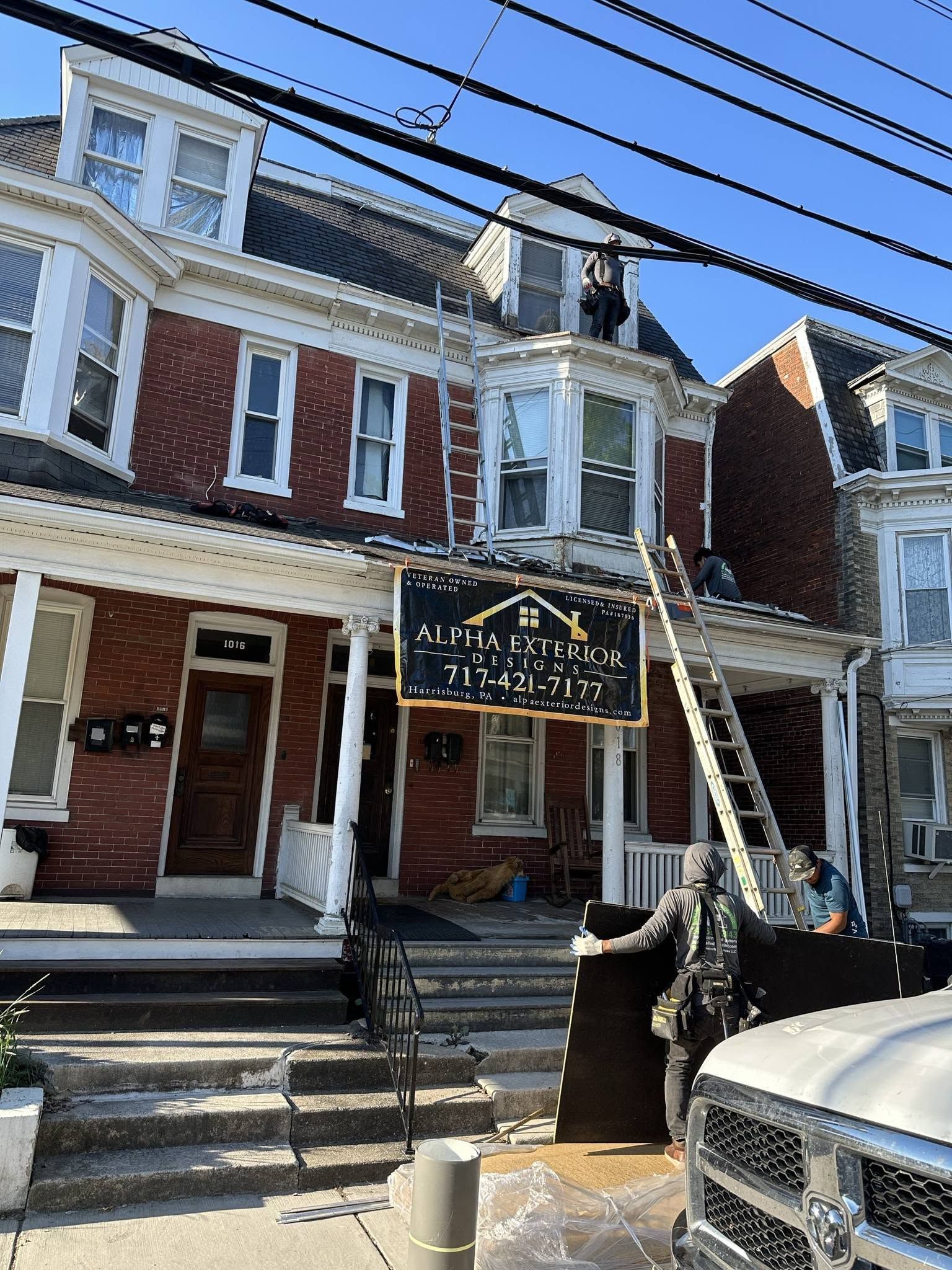 Historic brick building with a black-and-gold law office sign and a ladder leaning against the front.