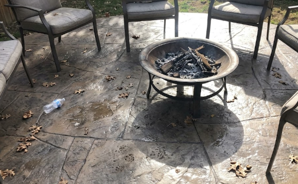 A decorative stamped concrete backyard patio resembling natural stone.