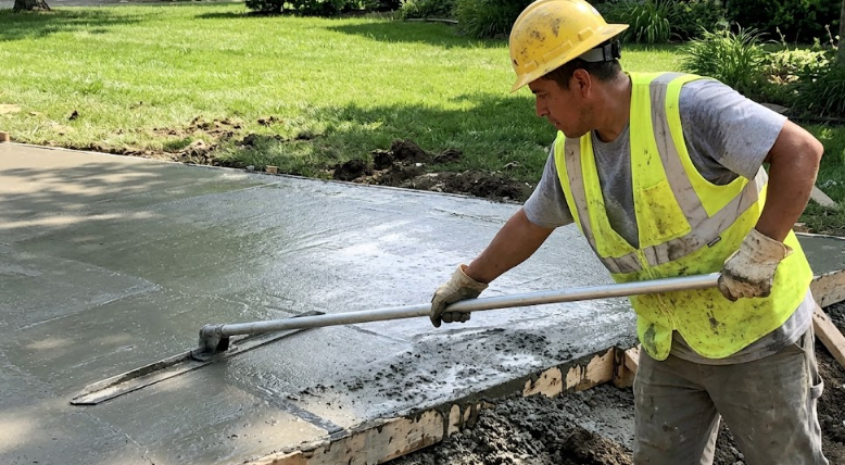 Pro Concrete Harrisonburg contractor smoothing a freshly poured cement slab.