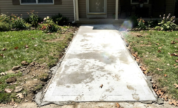 A safe, level concrete walkway leading to the front porch of a home.