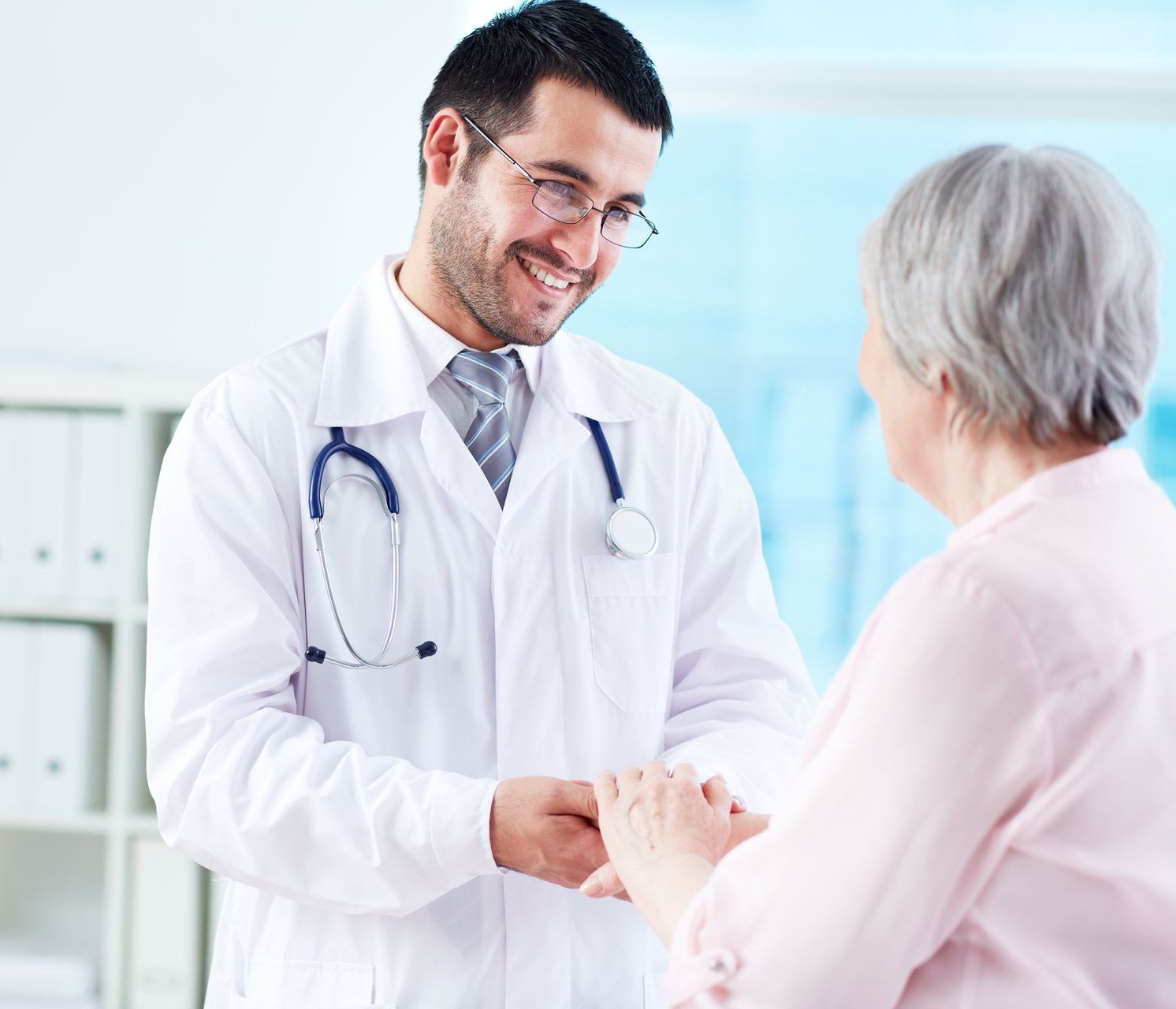 A doctor is shaking hands with an elderly woman