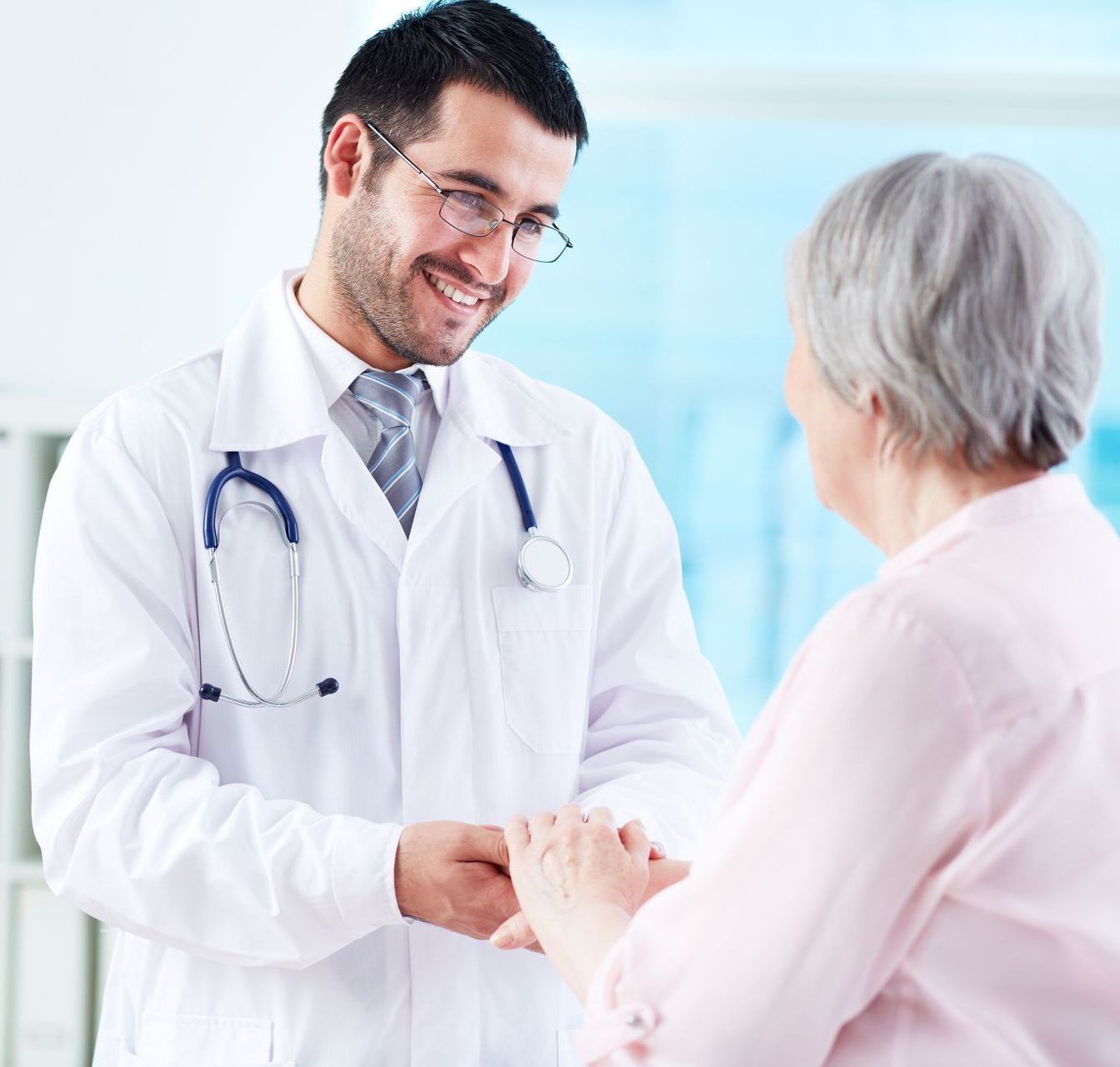 A doctor is shaking hands with an elderly woman