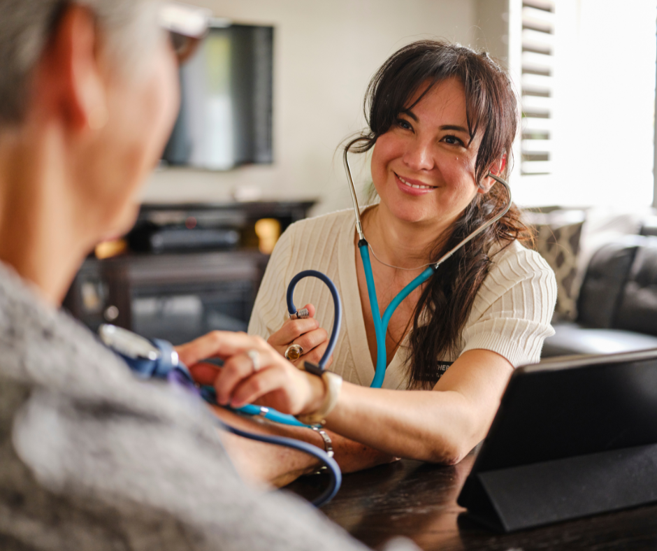 A medical provider is smiling while taking a patient's blood pressure