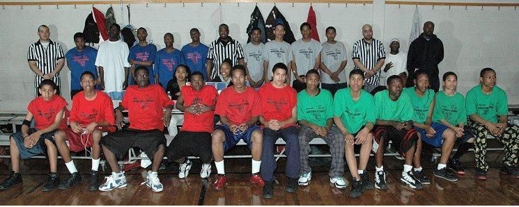 Group of people seated and standing indoors, wearing red and green shirts in a team photo