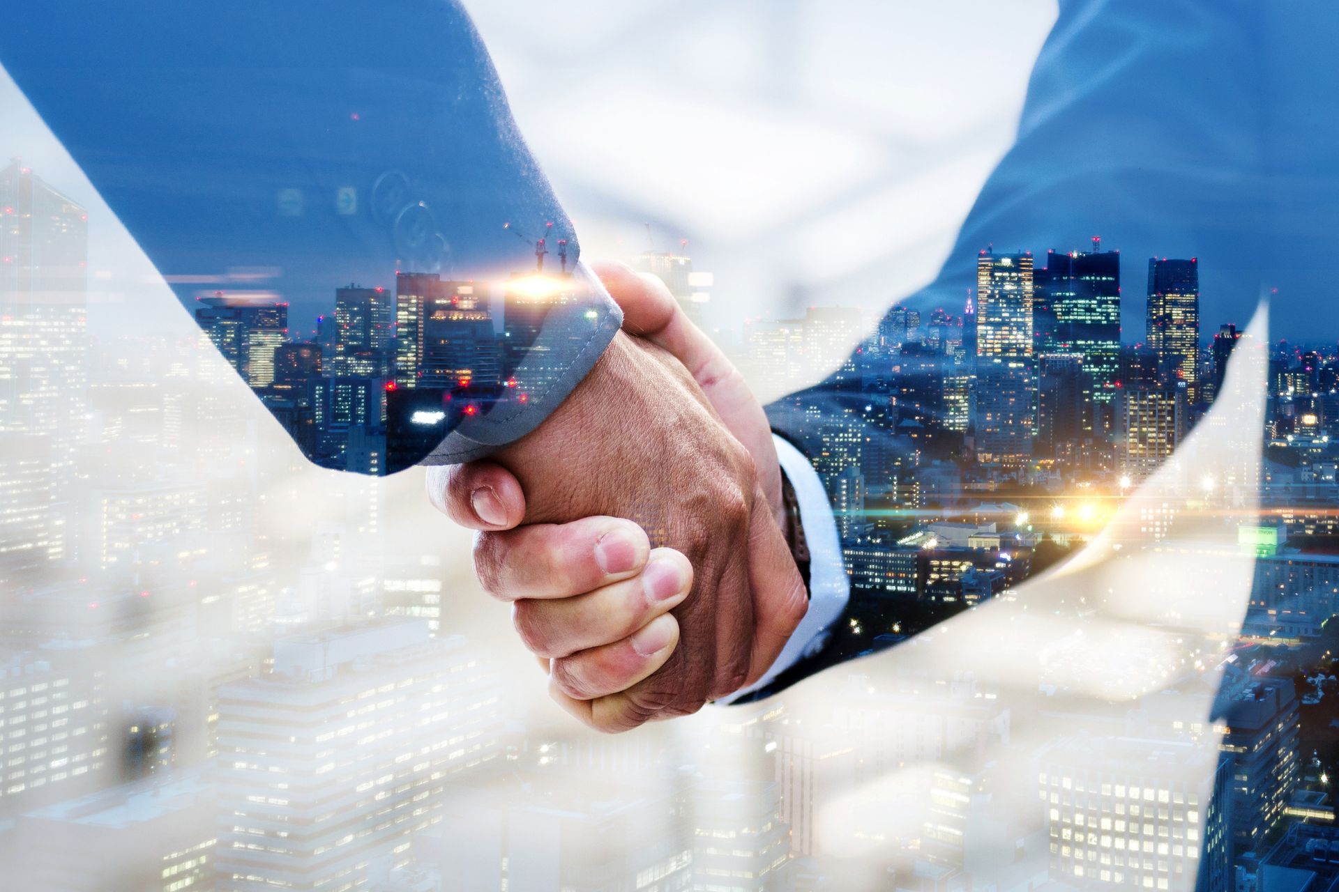 Two businessmen are shaking hands with a city skyline in the background.