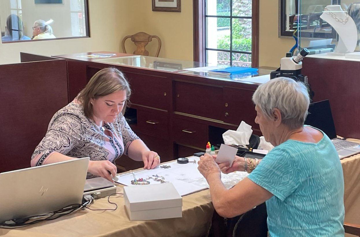 Two women are sitting at a table looking at a piece of paper.