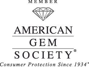 The logo for the american gem society is black and white with a diamond in the middle.
