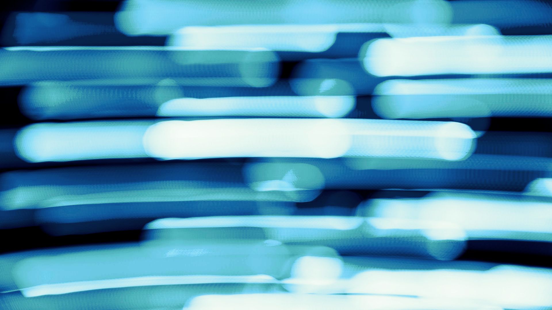 Abstract blue light streaks and blurred horizontal bands on a dark background