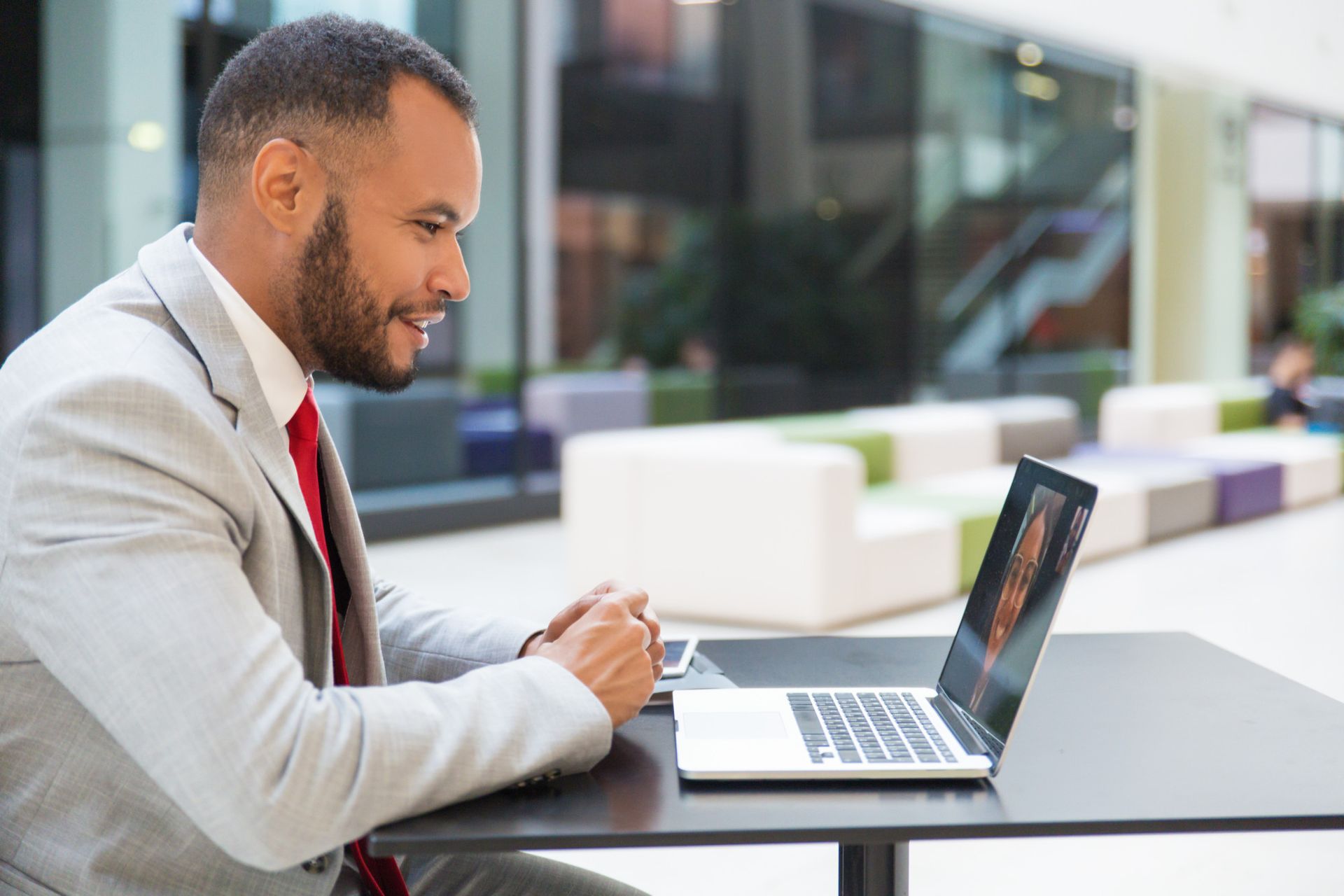 HR manager reviewing employee leave and attendance records on a laptop in a Caribbean office setting