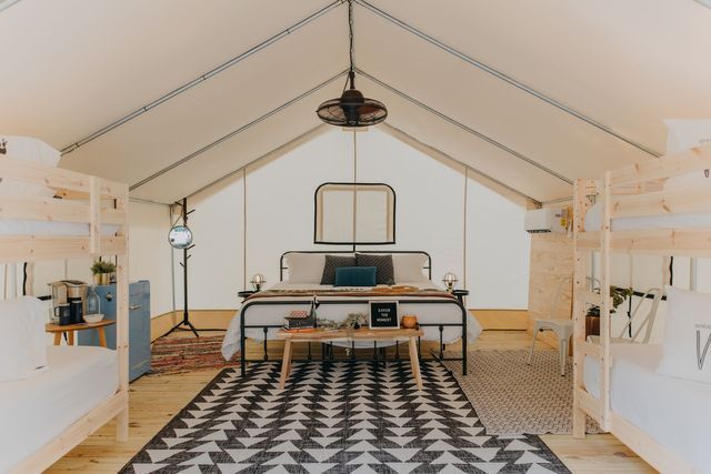 A tent with a bed and bunk beds inside of it.