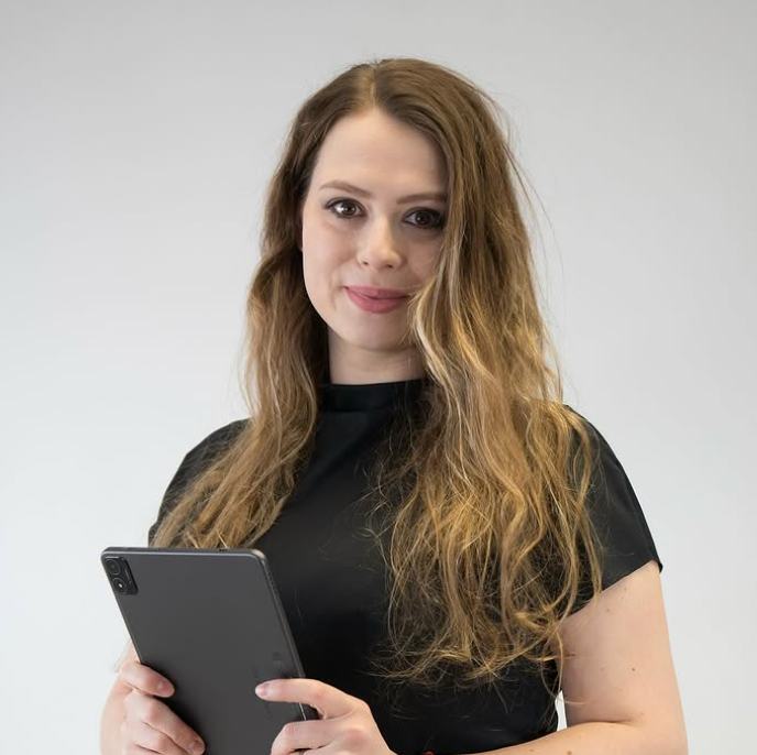 A woman in a black shirt is holding a tablet