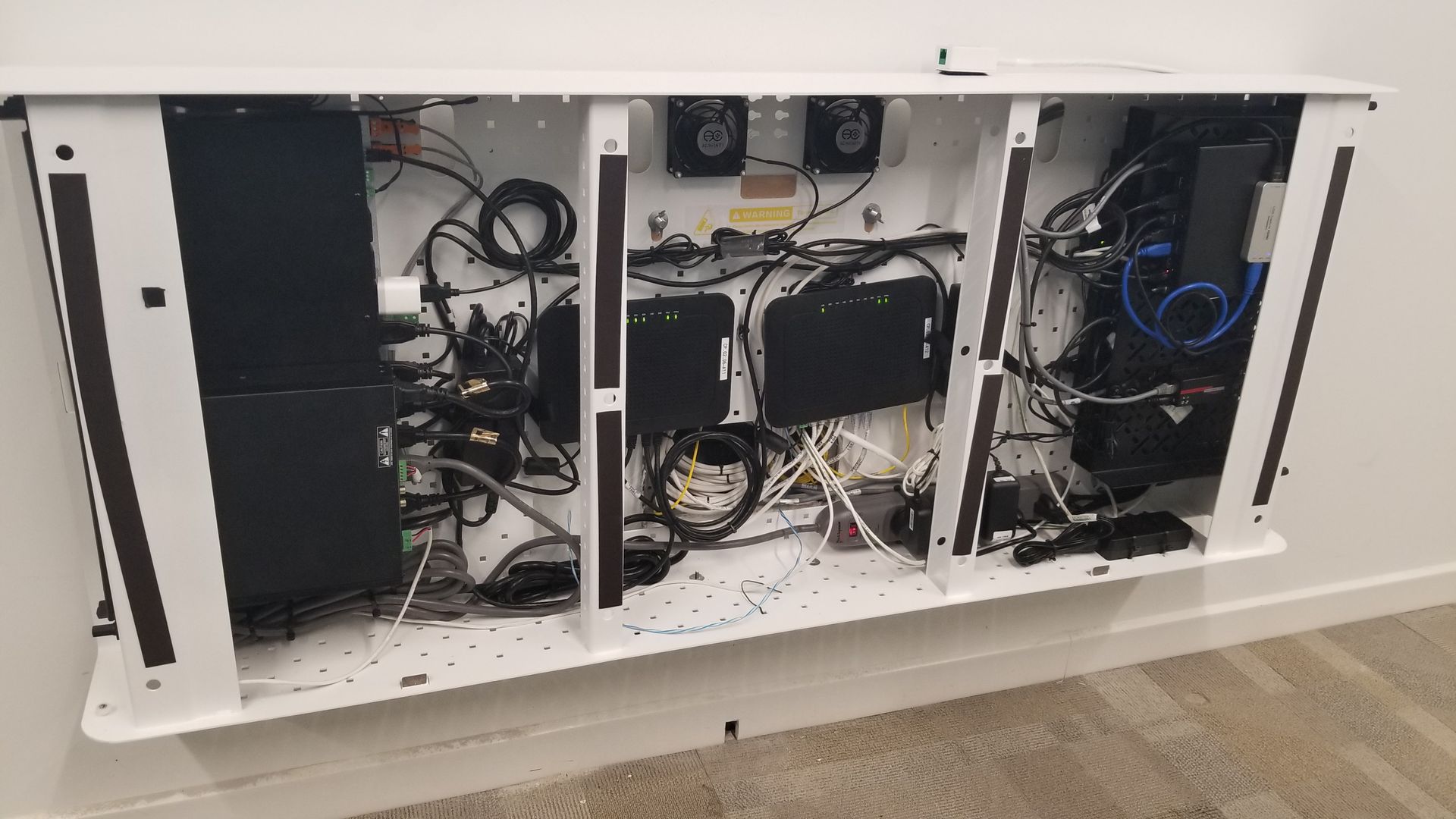 A white cabinet with a lot of wires coming out of it.