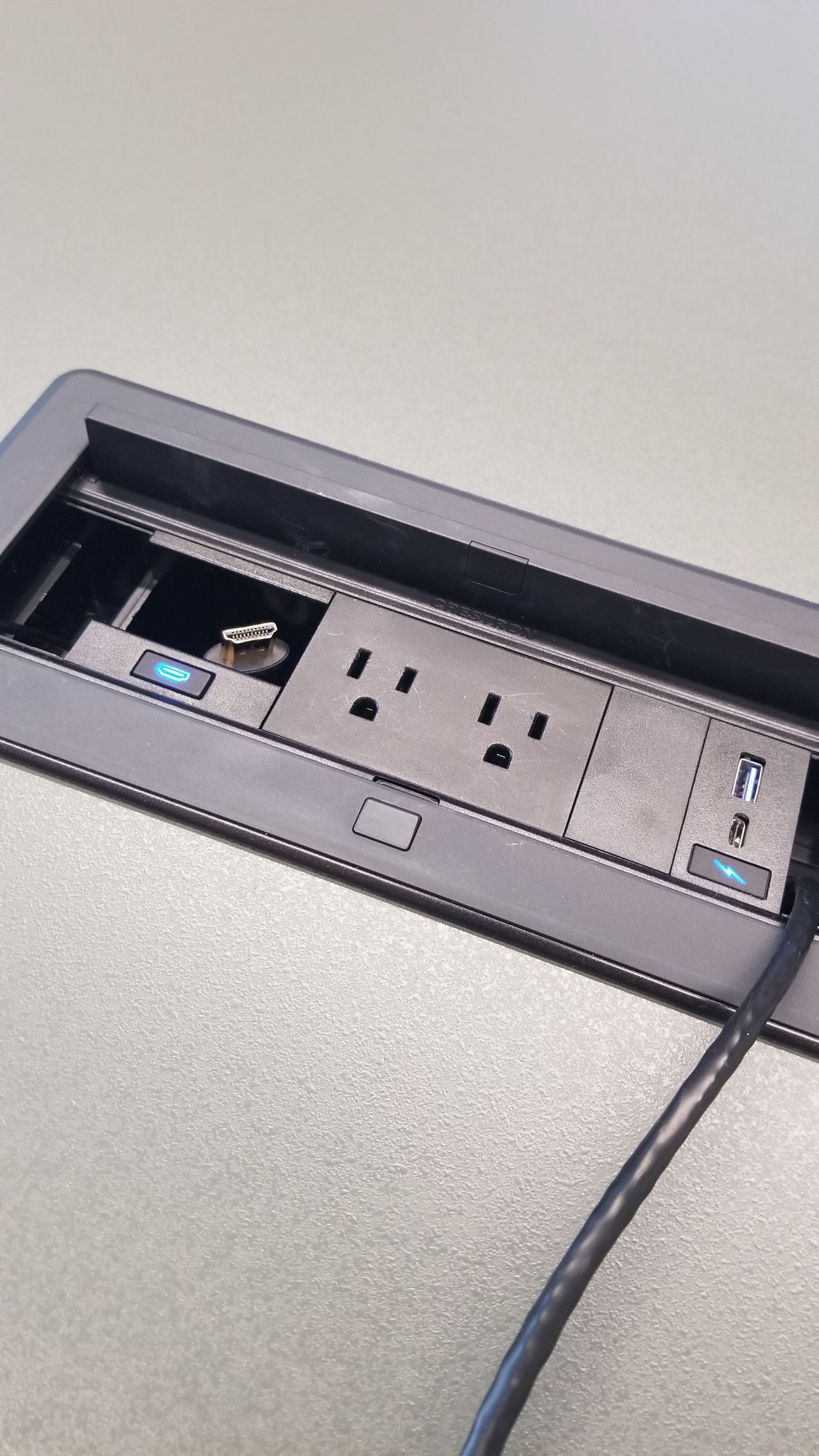 A close up of a electrical outlet with a cord plugged into it.